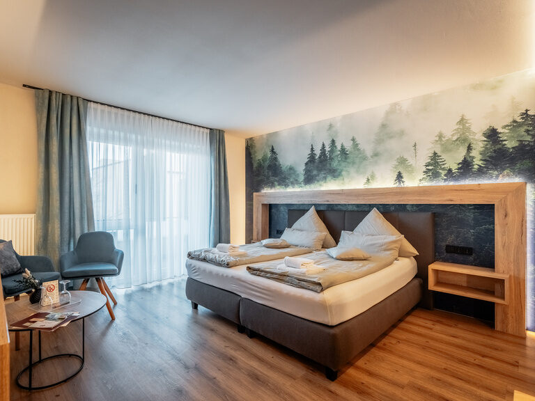 Ein großes, komfortables Bett im Doppelzimmer Deluxe mit Gemeinschaftsgarten.